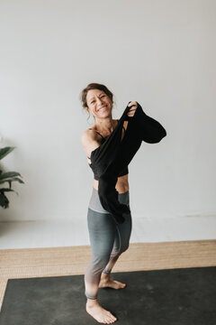 Woman putting on sweater in yoga studio