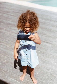Little girl using smartphone on porch