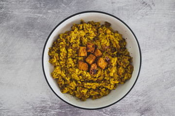 vegan lentil pilaf rice with turmeric and chinese spices topped with marinated tofu cubes, healthy plant-based food