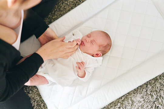 Mother bonding with baby on mattress