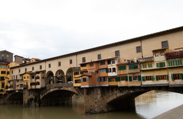 Fototapeta na wymiar Ponte Vecchio es un puente medieval sobre el río Arno, con comercios sobre él