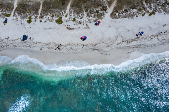 Beach umbrellas and holiday makers on beach, Oristano, Cagliari, Sardinia