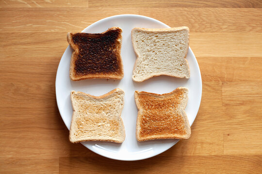 Four sliced bread on plate. Fresh, light toast, crispy toast and burnt