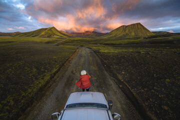 Woman traveller enjoying scenic view of volcanic mountains on vehicle, Landmannalaugar, Highlands, Iceland