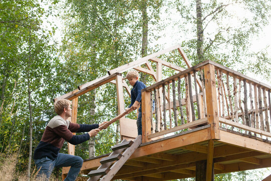 Father and son building treehouse together in garden