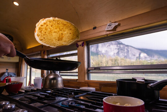 Man making pancake inside motorhome, Squamish, British Columbia, Canada