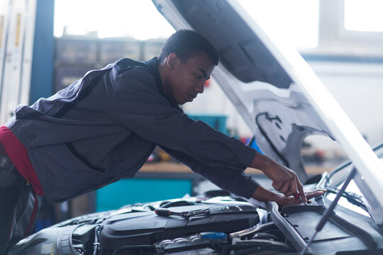 Workman fixing car windshield in workshop