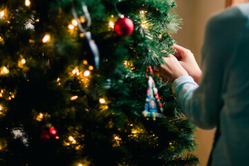 Person decorating Christmas tree at home