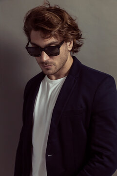 Man in jacket looking cool with sunglasses, grey background