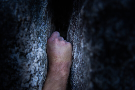 Hand wedged in a crack in a rock face, traditional climbing on granite, Tantalus Wall, Squamish