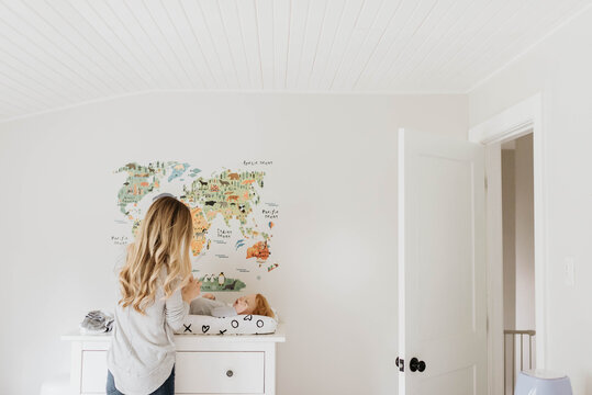 Mother changing toddler's diaper on changing table