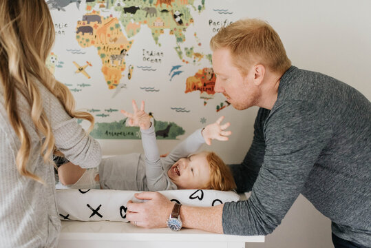Couple changing toddler's diaper on changing table