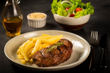 Grilled steak with french fries, brazilian farofa and salad.