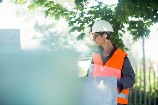 Woman Working Outdoors In A High Vis Jacket And Safety Hard Hat. 