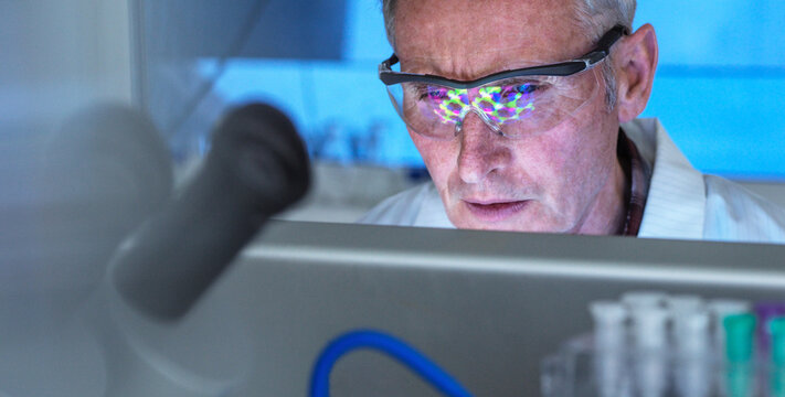 Scientist using a 3D molecular structure on screen, researching potential Covid-19 drug in the laboratory. Medical and clinical trials.