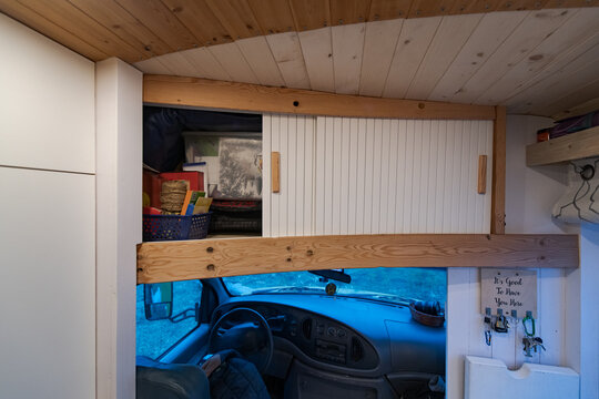 Cupboard over the campervan driving cabin with sliding doors.