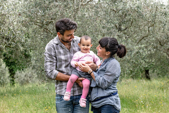 Couple with baby girl in garden, Florence, Italy