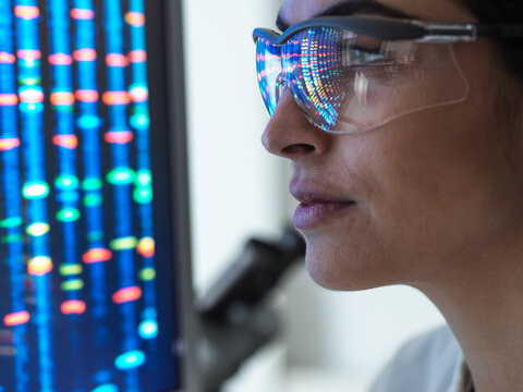 Genetic Research, female scientist viewing a DNA profile of a human sample on a screen in the lab.