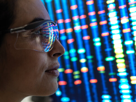 Genetic Research, female scientist viewing a DNA profile of a human sample on a screen in the lab.