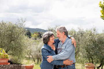 Portrait of senior couple, olive trees in background, Florence, Italy