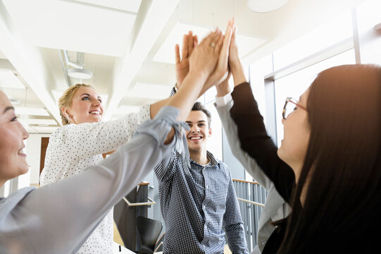 Colleagues giving high five in office