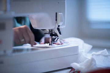Close up of female tailor using sewing machine.