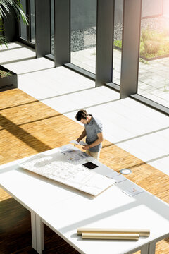 High angle view of young male architect working on an architectural model.