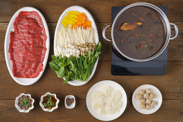 set menu of Thai style beef hot pot with thick chinese soup on wooden table