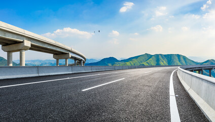 Naklejka premium Asphalt highway and green mountains in summer.