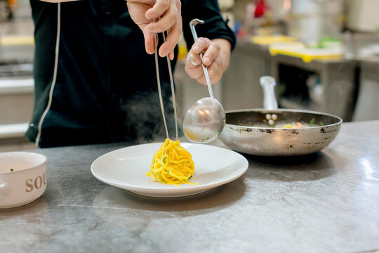 Chef preparing pasta in kitchen
