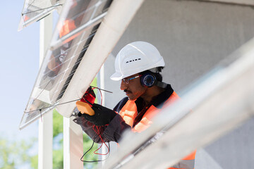 Male engineer wearing hardhat and ear protectors working on construction site.