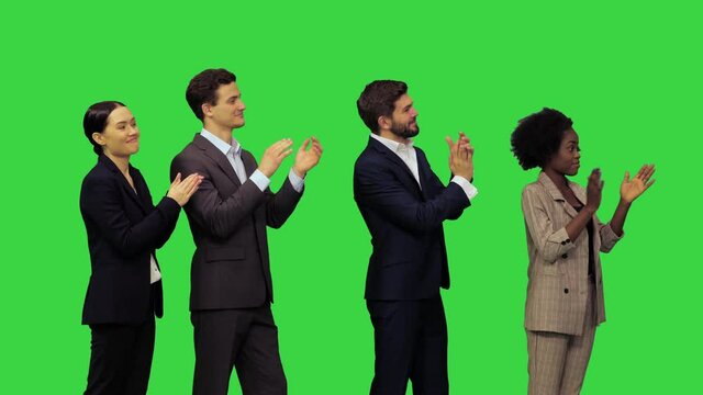 Young office people hearing some pleasant news and start clapping on a Green Screen, Chroma Key.
