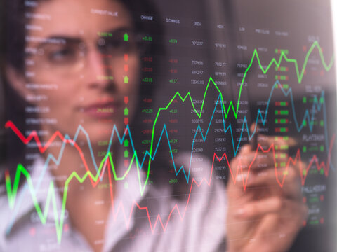 Female analyst viewing financial market data on a screen.