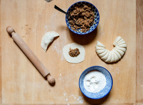 High Angle Close Up Of Gyoza Ingredients And Rolling Pin On Wooden Board In A Ramen And Gyoza Restaurant In Italy.