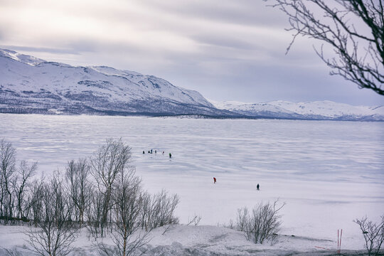 View across frozen lake with people in the distance, Vasterbottens Lan, Sweden.