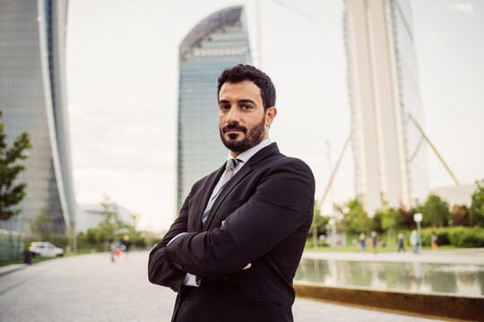 Portrait of bearded businessman wearing dark suit, looking at camera.