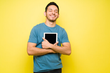Attractive man embracing and using his tablet