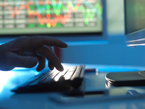 Close up of stock market trader analysing share price data on the screen.