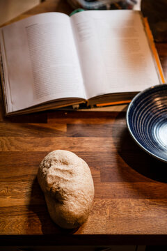 High angle close up of freshly baked bread and open book on a table.