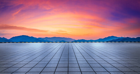 City square floor and green mountains in summer at sunrise.