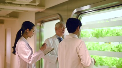 野菜工場の水耕栽培設備・話し合う研究員