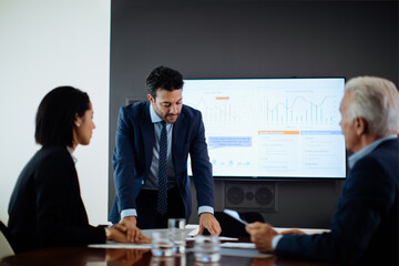 Businessmen and woman meeting at boardroom table
