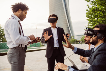 Mixed race group of businessmen hanging out together in town, wearing VR headsets.