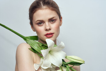 Lady with a bouquet of white flowers on a gray background portrait cropped view close-up
