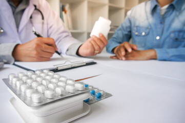 Medicine Doctor hand holding pack of different tablet blisters for patient. prescribe medicament. disease healing concept. Packaging of tablets and pills on the table.