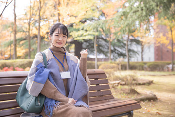 Fototapeta premium 秋の公園にいる会社員の女性 