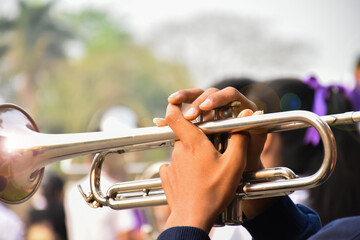 Trumpet instrument holding in hands of Asian student who playing it at a ceremony to honor the...