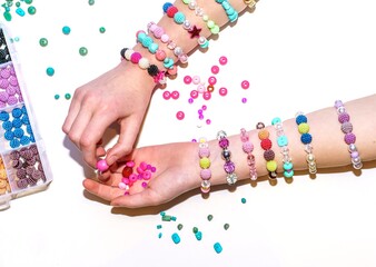 girl making colorful bead bracelets - obrazy, fototapety, plakaty
