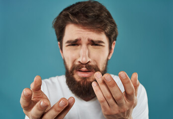 Naklejka premium Man gesturing with his hands on a blue background closeup portrait of emotion