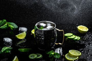 Obraz na płótnie Canvas Moscow mule cocktail with lime, mint and cucumber. alcoholic cocktail in copper mugs, freeze motion effect